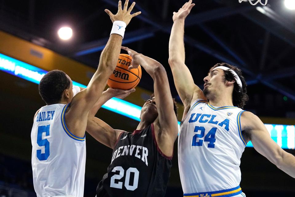 Denver guard Justin Mullins, center, shoots as UCLA guard Amari Bailey, left, and guard Jaime Jaquez Jr. defend during the first half of an NCAA college basketball game Saturday, Dec. 10, 2022, in Los Angeles. (AP Photo/Mark J. Terrill)