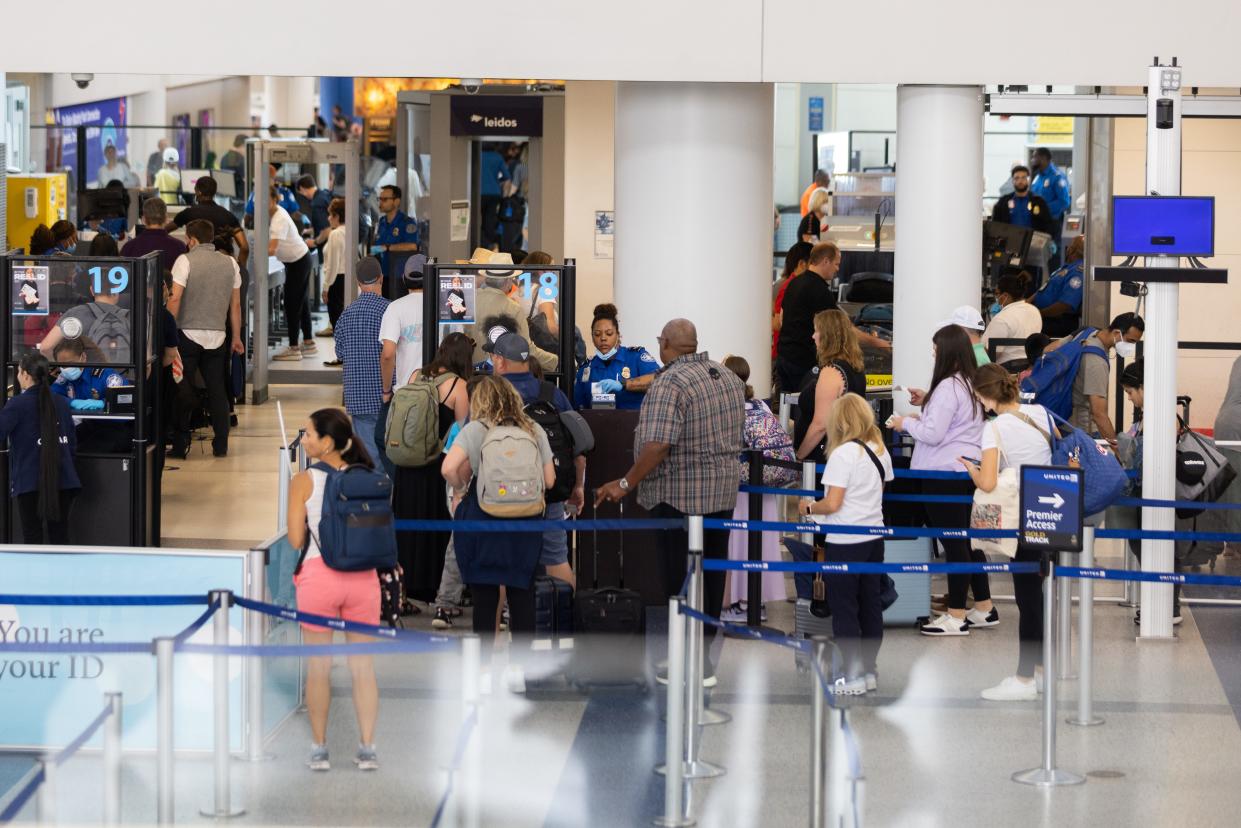 Travelers line up to enter a security checkpoint at Newark Liberty International Airport on July 1, 2022.