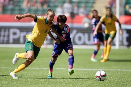 Jun 27, 2015; Edmonton, Alberta, CAN; Japan defender Saori Ariyoshi (19) and Australia forward Caitlin Foord (9) compete for the ball during the second half in the quarterfinals of the FIFA 2015 Women's World Cup at Commonwealth Stadium. Mandatory Credit: Erich Schlegel-USA TODAY Sports