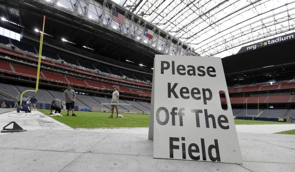 Grounds crew members paint the New England Patriots logo on the field at NRG Stadium Tuesday, Jan. 24, 2017, in Houston. The New England Patriots will play the Atlanta Falcons in NFL football's Super Bowl LI, Sunday, Feb. 5, 2017. (AP Photo/David J. Phillip)