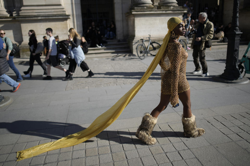 A fashion lovers walks in the courtyard of the Louvre museum during Louis Vuitton ready-to-wear Spring/Summer 2023 fashion collection presented Tuesday, Oct. 4, 2022 in Paris. (AP Photo/Christophe Ena)