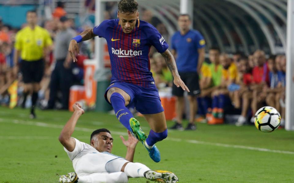 Real Madrid's Casemiro, left, falls to the field as he vies for the ball with Barcelona's Neymar, right, during the first half of an International Champions Cup soccer match, Saturday, July 29, 2017, in Miami  - Credit: AP