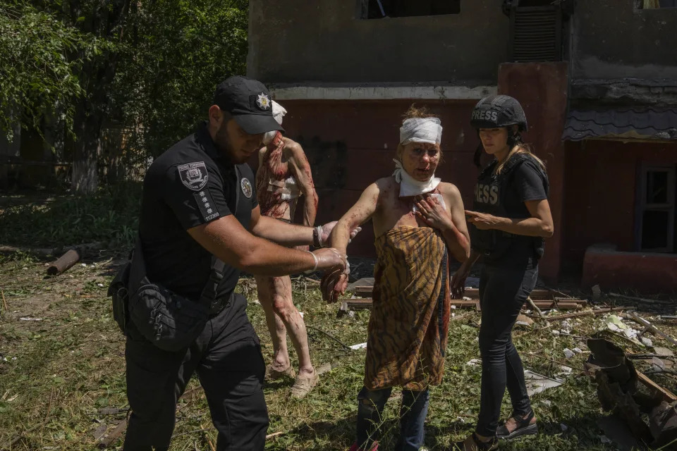 FILE - A policeman helps an injured woman after a missile strike hit a residential area, in Kramatorsk, Donetsk region, eastern Ukraine, Thursday, July 7, 2022. Injured residents sat dazed and covered in blood. Last week, the governor of the Donetsk oblast Pavlo Kyrylenko urged the province's more than 350,000 remaining residents to flee to safer towns further West, saying that evacuating the region was necessary to save lives and allow the Ukrainian army to better defend towns against a Russian advance. Many refuse to leave the city. (AP Photo/Nariman El-Mofty, File)