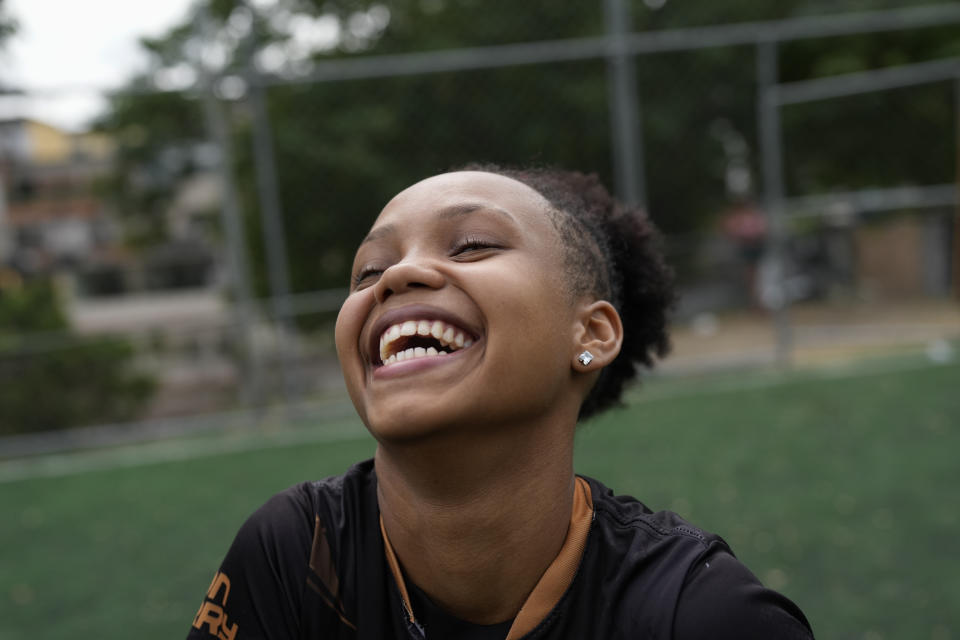 Agatha smiles during a soccer training session run by the Bola de Ouro social program, at the Complexo da Alemao favela in Rio de Janeiro, Brazil, Thursday, May 16, 2024. Young women are participating in soccer programs led by community trainers, where they receive both sports and personal development training. (AP Photo/Silvia Izquierdo)