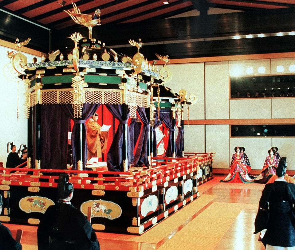 FILE - In this Nov. 12, 1990, file photo, Japan's Emperor Akihito reads an address on Takamikura throne as he formally ascends to the Chrysanthemum Throne at the Imperial Palace in Tokyo. The special imperial throne for the coronation of Japan’s new emperor arrived in Tokyo on Wednesday, Sept. 26, 2018, from the ancient imperial palace in Kyoto more than a year ahead of time. The Takamikura throne will be used at a ceremony in October 2019 when Crown Prince Naruhito formally announces his succession. (Kyodo News via AP, File)