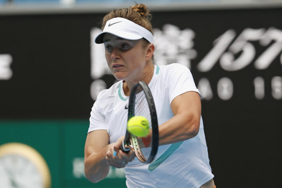 Elina Svitolina of Ukraine plays a backhand return to Fiona Ferro of France during their first round match at the Australian Open tennis championships in Melbourne, Australia, Monday, Jan. 17, 2022. (AP Photo/Hamish Blair)