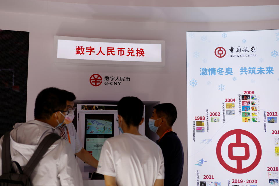 A staff member tends to visitors at an automated teller machine (ATM) offering services for China's digital yuan, or e-CNY, at the Bank of China booth during the 2021 China International Fair for Trade in Services (CIFTIS) in Beijing, China September 4, 2021. REUTERS/Florence Lo