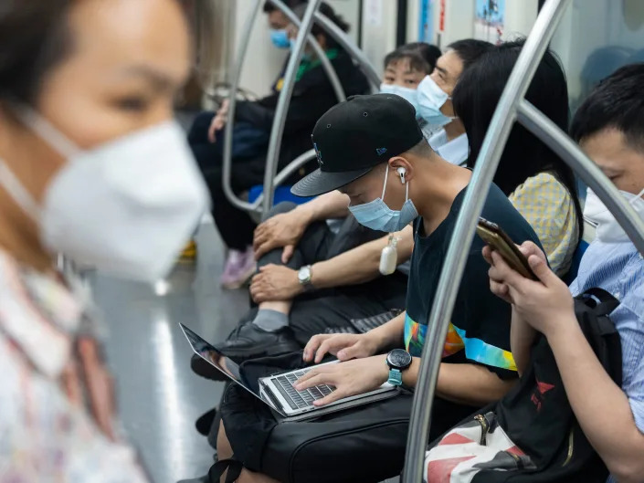 A man works with his laptop at subway car on June 02, 2022 in Shanghai, China.
