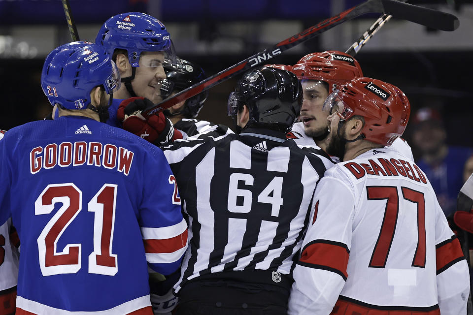 Carolina Hurricanes defenseman Tony DeAngelo (77) and New York Rangers center Matt Rempe, second from left, exchange words in the first period during Game 5 of an NHL hockey Stanley Cup second-round playoff series Monday, May 13, 2024, in New York. (AP Photo/Adam Hunger)