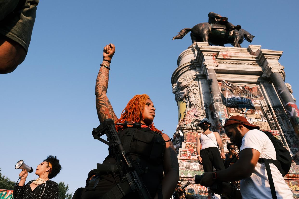 A woman with a gun poses for photos during the Black Women Matter "Say Her Name" march at the Lee statue on July 3, 2020, in Richmond, Va. Protests continue around the country after the death of African Americans while in police custody.