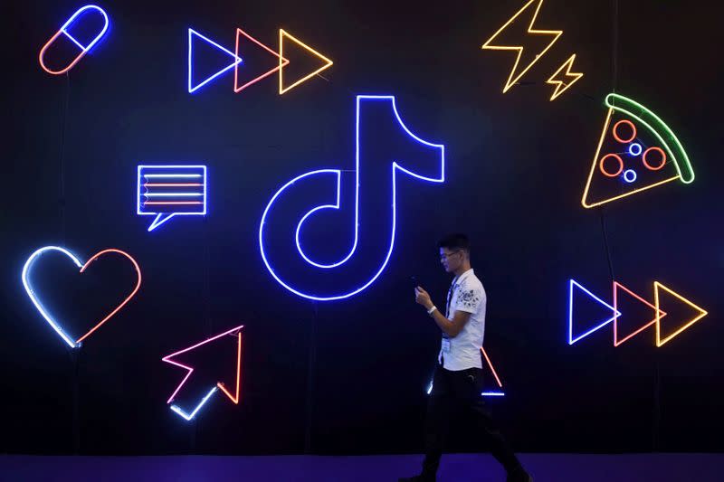 FILE PHOTO: Man walks past a sign of ByteDance's app TikTok, known locally as Douyin, at an expo in Hangzhou