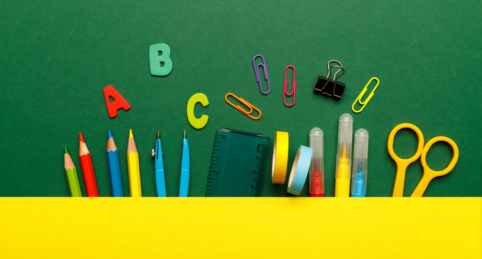 green and yellow background with school supplies on display, pens, pencils, rule, scissors, clips, Best school supplies deals from Amazon Canada: Markers, notebooks, sticky notes, and more (Photo via Getty)