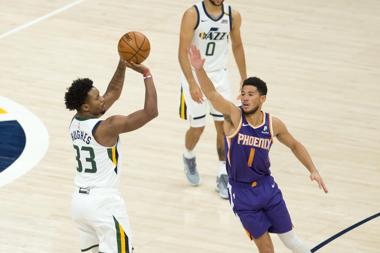 Dec 14, 2020; Salt Lake City, Utah, USA; Utah Jazz forward Elijah Hughes (33) shoots the ball against Phoenix Suns guard Devin Booker (1) during the second half at Vivint Smart Home Arena. Mandatory Credit: Russell Isabella-USA TODAY Sports