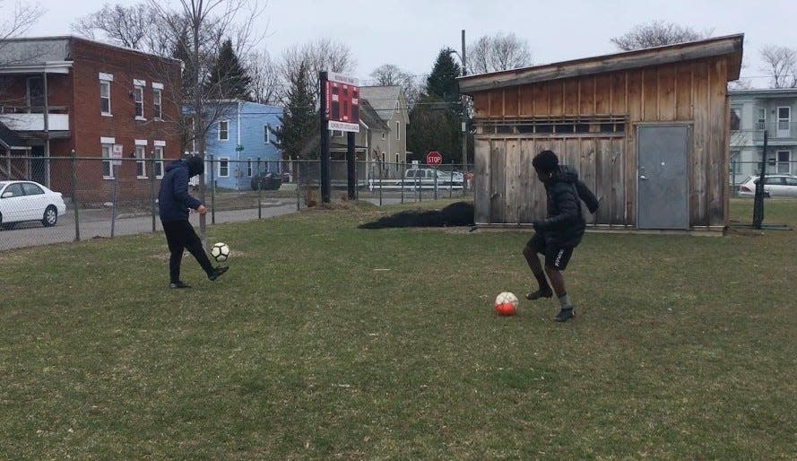 Oliver Alimasi, 15, right, and Kong Say, 15, both of Burlington, play with individual soccer balls they brought to Roosevelt Park in Burlington on Thursday, April 2, 2020.