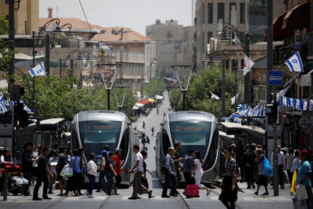 FILE PHOTO: Pedestrians cross a street next to the light rail trams in Jerusalem May 11, 2017. REUTERS/Amir Cohen/File Photo