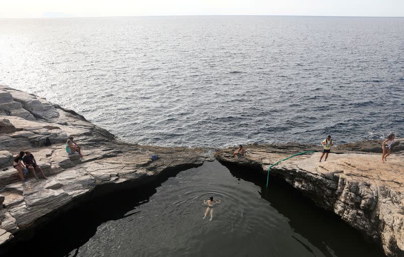 FILE PHOTO: A tourist swims in Giola, a natural pool next to the sea in Thassos island