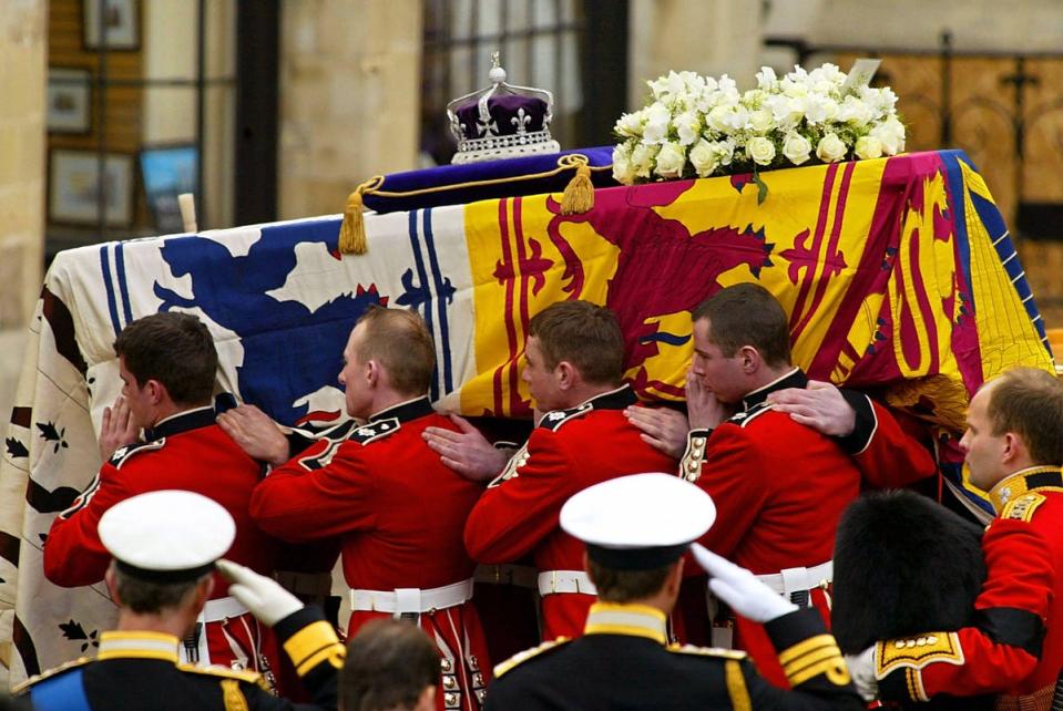 Pall Bearers carry the coffin of Queen Elizabeth, the Queen Mother from the gun carriage on which it travelled from Westminster Hall to Westminster Abbey in London for the funeral service (AFP via Getty Images)