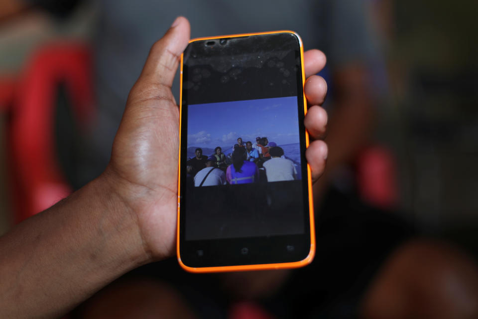 A friend of Maroly Bastardo shows a picture of the boat that Bastardo and her family boarded, in Guiria, Venezuela, on May 24. (Photo: Ivan Alvarado/Reuters)