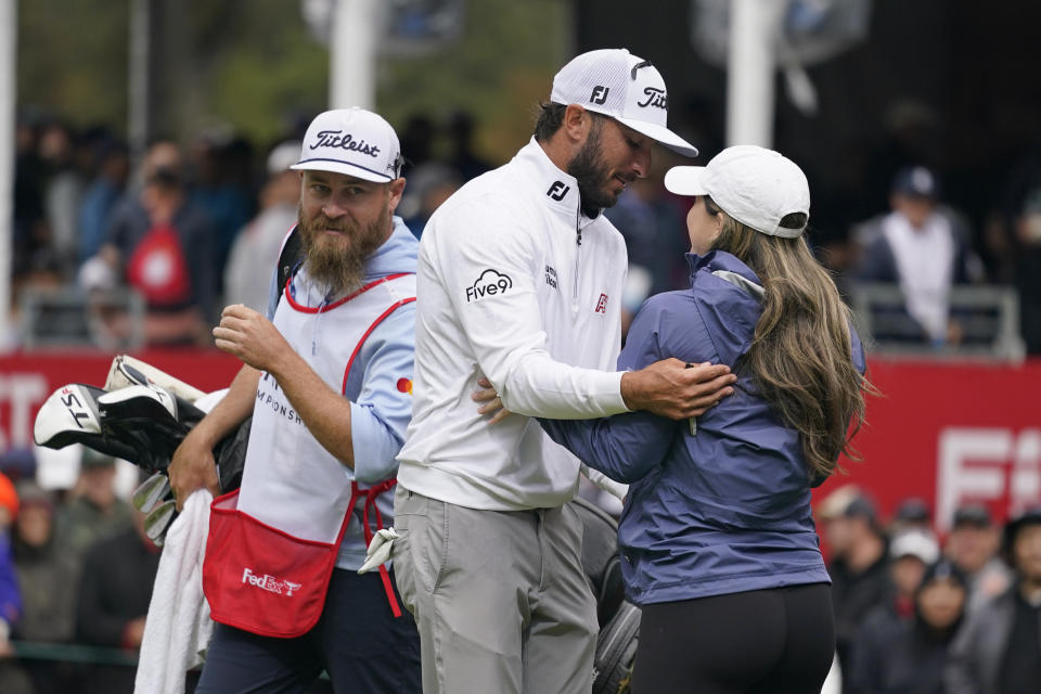 FILE - Max Homa, center, is greeted by his wife Lacey, right, on the 18th green of the Silverado Resort North Course after winning the Fortinet Championship PGA golf tournament in Napa, Calif., Sept. 18, 2022. Homa says his wife knew nothing about golf on their first date. (AP Photo/Eric Risberg, File)