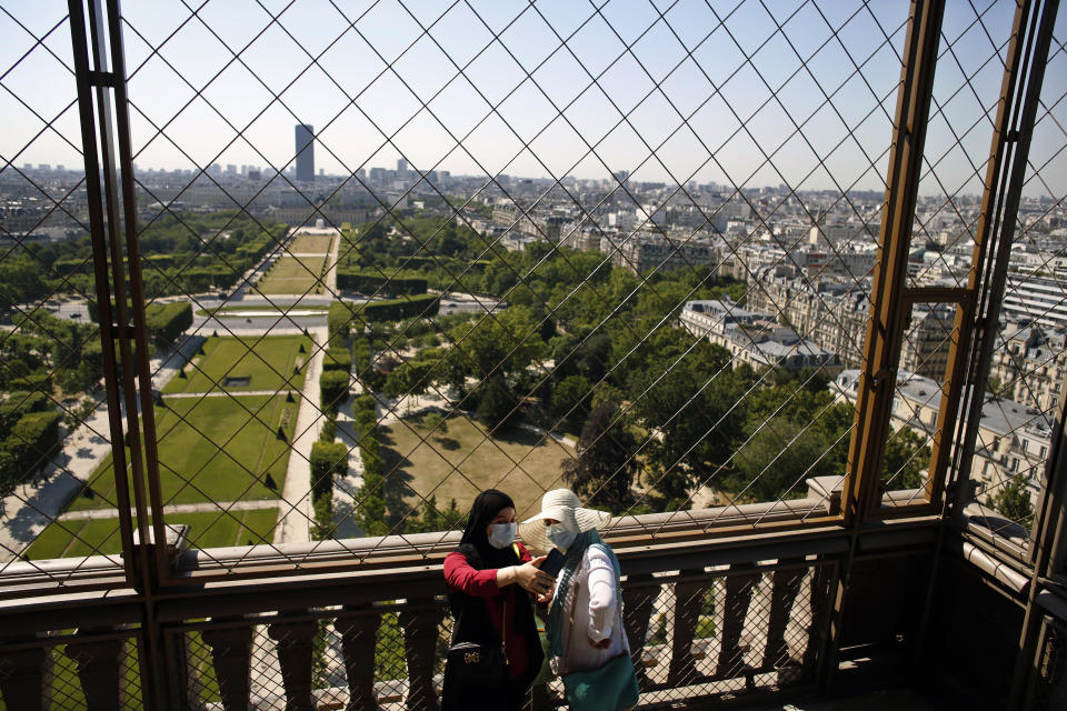 Visitors take a selfie from the first floor of the Eiffel Tower, in Paris, Thursday, June 25, 2020. The Eiffel Tower reopens after the coronavirus pandemic led to the iconic Paris landmark's longest closure since World War II. (AP Photo/Thibault Camus)