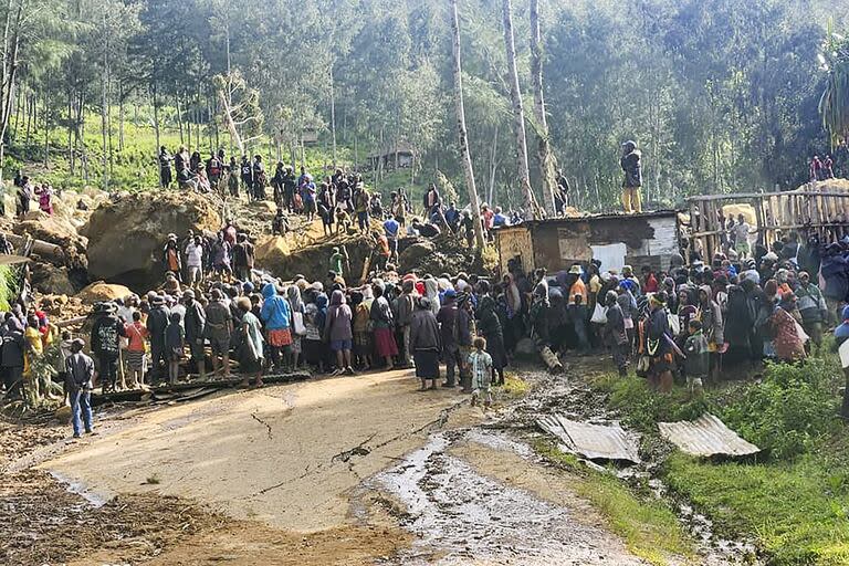 Unos aldeanos reaccionan tras descubrirse un cadáver entre los escombros de un corrimiento de tierras en la aldea de Yambali, en las tierras altas de Papúa Nueva Guinea.