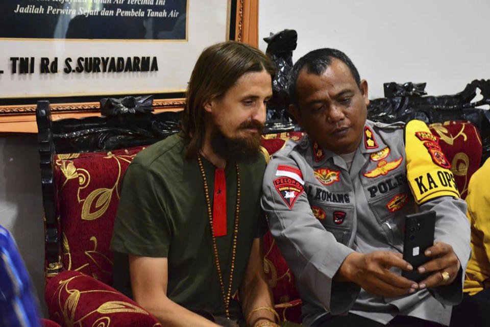 In this photo released by Cartenz Peace Task Force (Satgas Damai Cartenz) of the Indonesian security forces, New Zealand pilot Phillip Mehrtens, left, who was held hostage for more than a year in the restive Papua region, sits with a police officers after his release, in Timika, Papua province, Saturday, Sept. 21, 2024. (Satgas Damai Cartenz via AP)