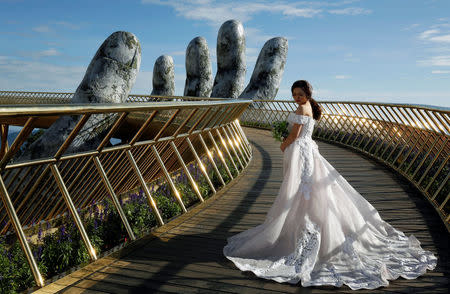 A Vietnamese bride poses for her wedding photos on Gold Bridge on Ba Na hill near Danang city, Vietnam August 1, 2018. REUTERS/Kham