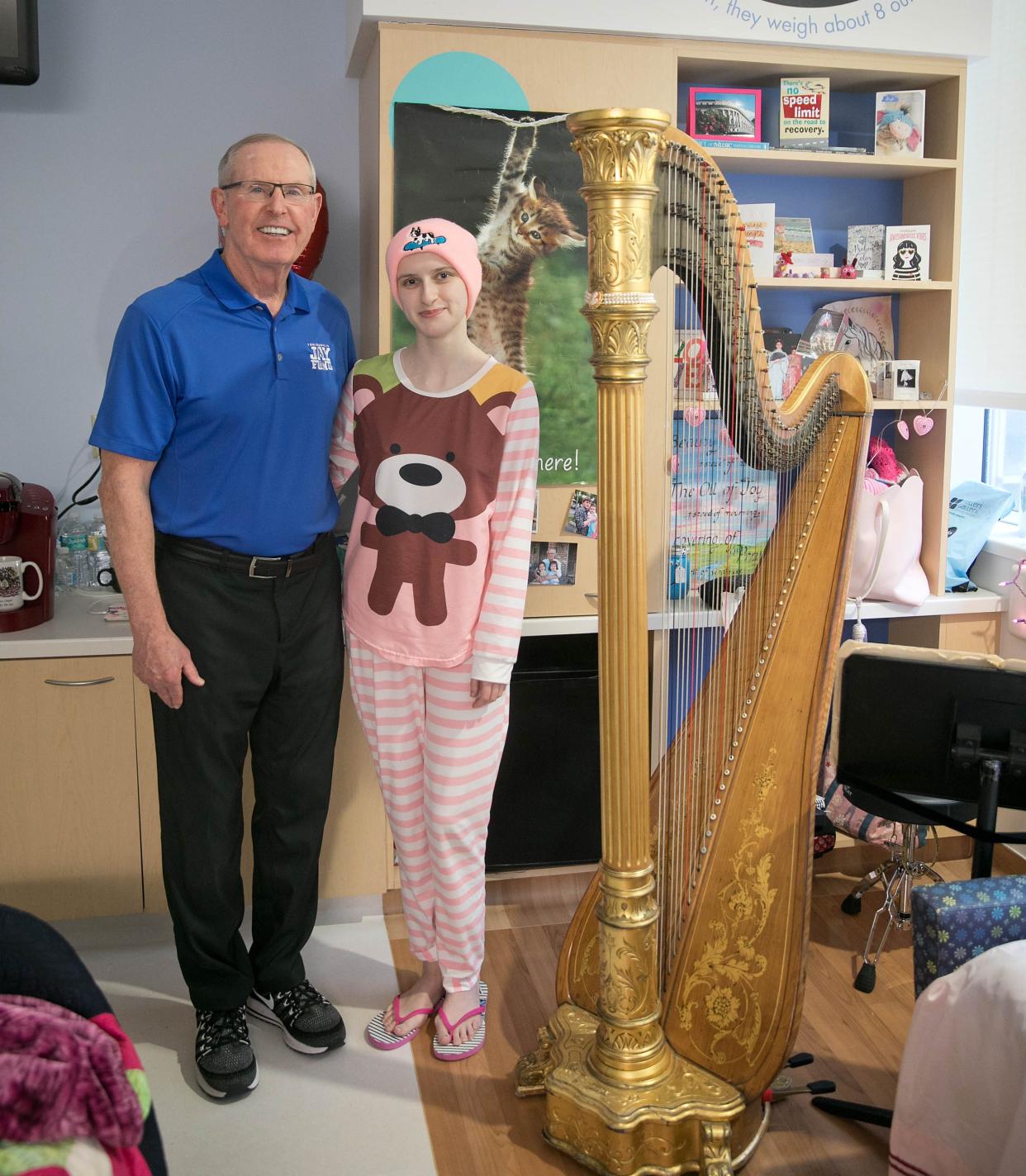 Isabelle Scott (right) is pictured with Tom Coughlin during her cancer treatment in 2018. Scott's father arranged for the music student's harp to be delivered to her hospital room, where she performed for the former NFL coach and president of the Jay Fund, a nonprofit devoted to helping families of children with cancer.