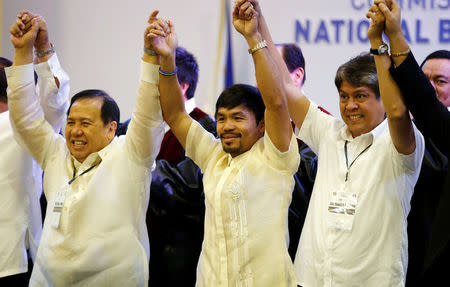 REFILE - CORRECTING IDENTITY OF SENATOR ON THE RIGHT Philippine boxing star and Senator Manny Pacquiao raises arms with other newly elected senators Dick Gordon (L) and Kiko Pangilinan (R) in Manila, Philippines May 19, 2016. REUTERS/Erik De Castro