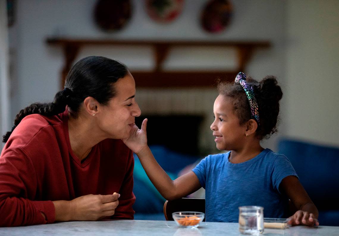 Mavis Daye, 5, right, and her mother, Kat Tedford, share a snack after school on Monday, May 9, 2022, at their home in Durham, N.C.