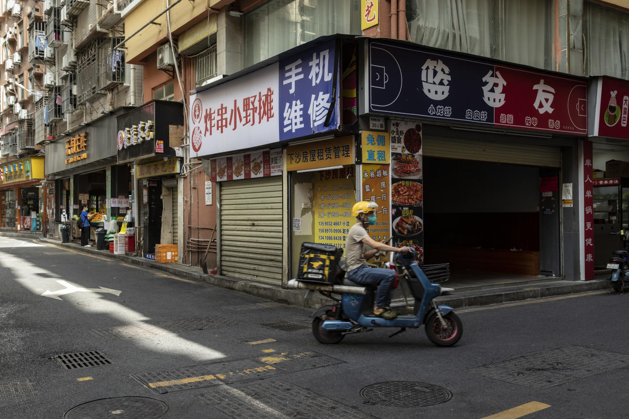 Un repartidor de comida pasa enfrente de tiendas cerradas en el pueblo de Xiasha en Shenzhen, China, el 16 de noviembre de 2022. (Qilai Shen/The New York Times)