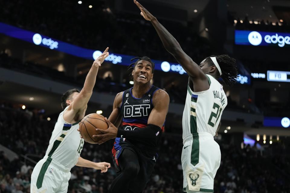 Detroit Pistons' Jaden Ivey shoots between Milwaukee Bucks' Jrue Holiday and Grayson Allen during the first half of an NBA basketball game Wednesday, Nov. 2, 2022, in Milwaukee. (AP Photo/Morry Gash)