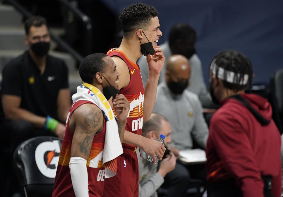 Denver Nuggets guard Monte Morris, front, and forward Michael Porter Jr. pull down their face masks to celebrate as time runs out in the team's NBA basketball game against the Miami Heat on Wednesday, April 14, 2021, in Denver. (AP Photo/David Zalubowski)