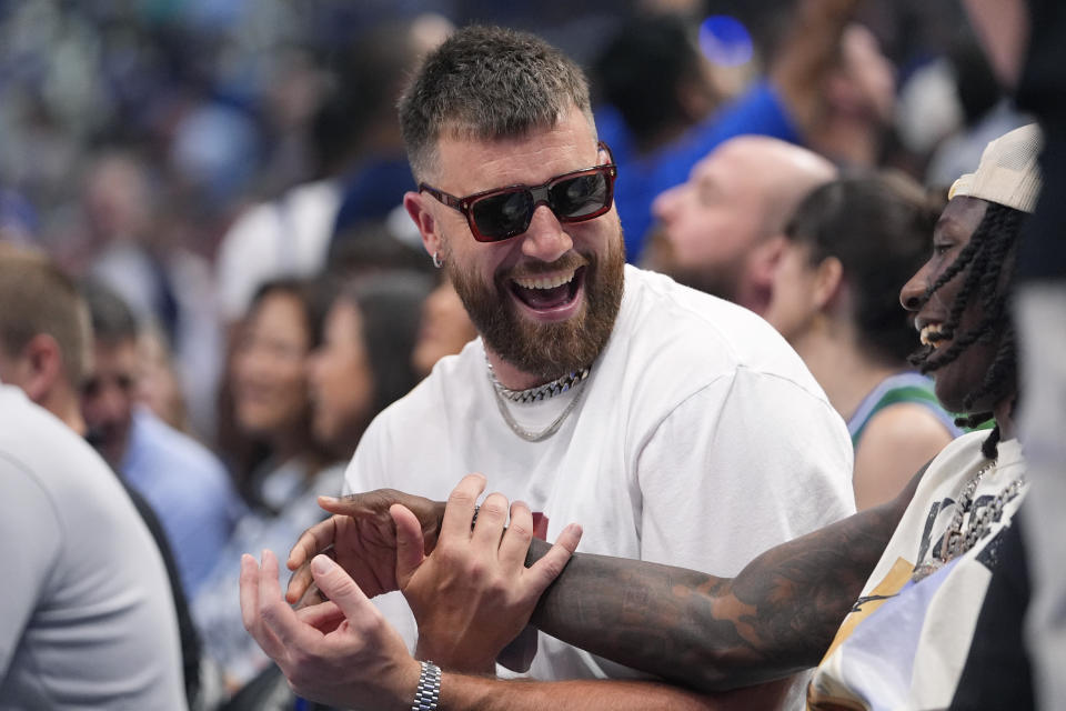 Kansas City Chiefs tight end Travis Kelce, center, attends Game 3 of the NBA basketball Western Conference finals between the Dallas Mavericks and the Minnesota Timberwolves, Sunday, May 26, 2024, in Dallas. (AP Photo/Julio Cortez)