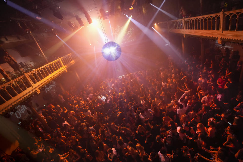 People dance in close proximity at Paradiso pop venue, club and cultural center, in Amsterdam, Saturday, Sept. 25, 2021, the day The Netherlands dropped the coronavirus related 1.5 meter (5 feet) rule. Paradiso is housed in a converted former church building that dates from the nineteenth century. (AP Photo/Peter Dejong)