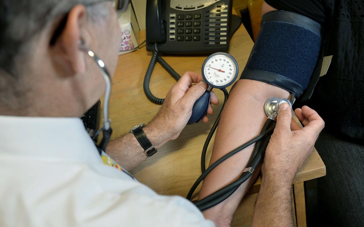 a GP checking a patient's blood pressure