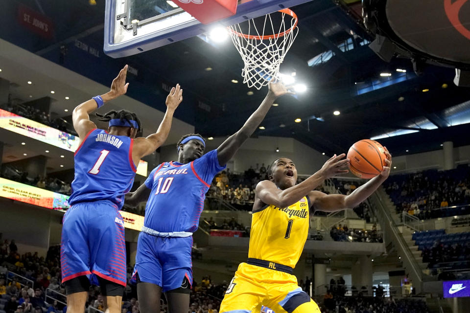 Marquette's Kam Jones (1) scores past DePaul's Javan Johnson (1) and Yor Anei during the first half of an NCAA college basketball game, Saturday, Jan. 28, 2023, in Chicago. (AP Photo/Charles Rex Arbogast)