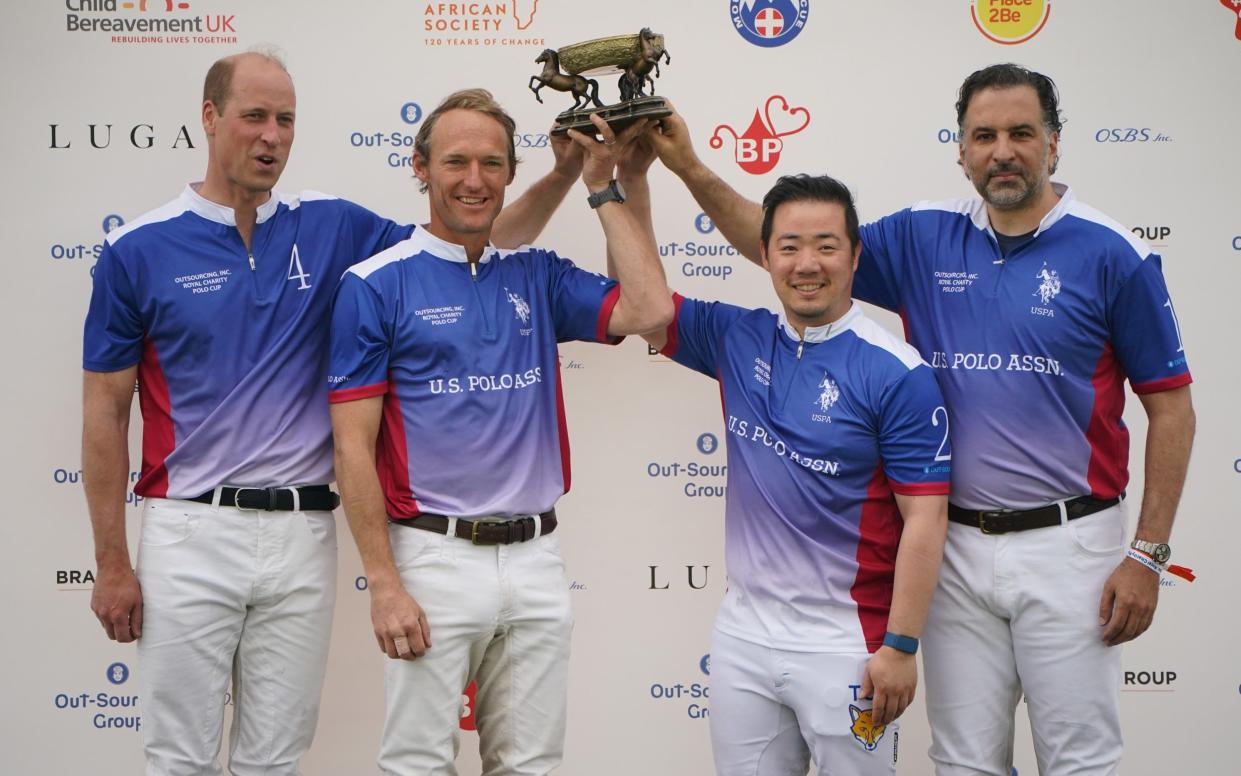 The Prince of Wales and his teammates (left to right) Mark Tomlinson, Aiyawatt Srivaddhanaprabha and Amr Zedan lift a trophy at the event