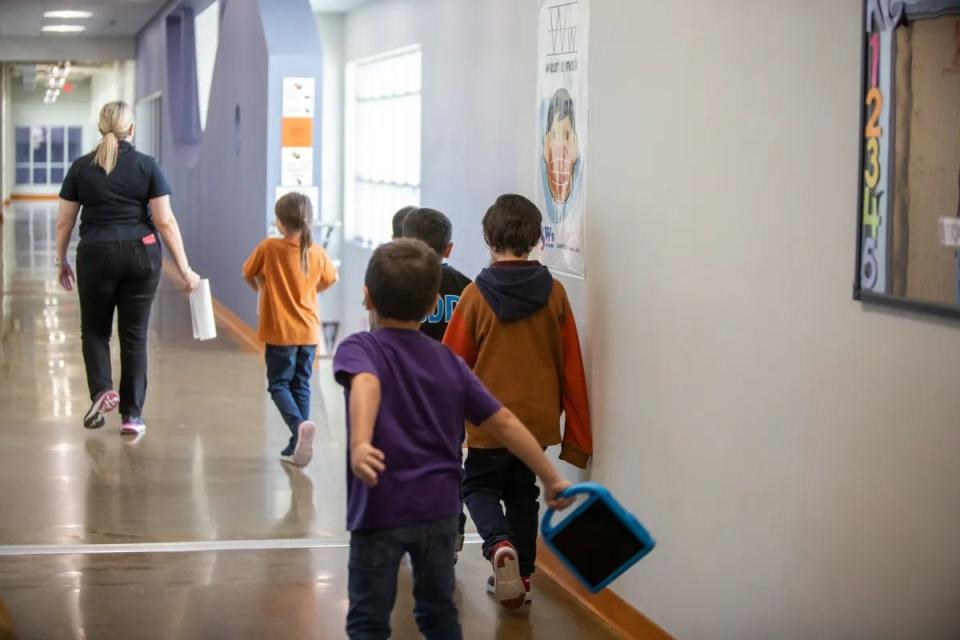 Students walk with a teacher at Reyes Elementary School on Nov. 29.