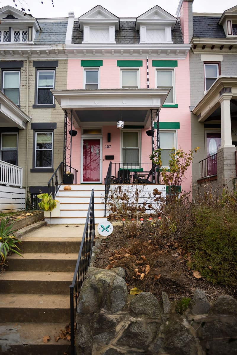 Exterior of pink and green townhouse.