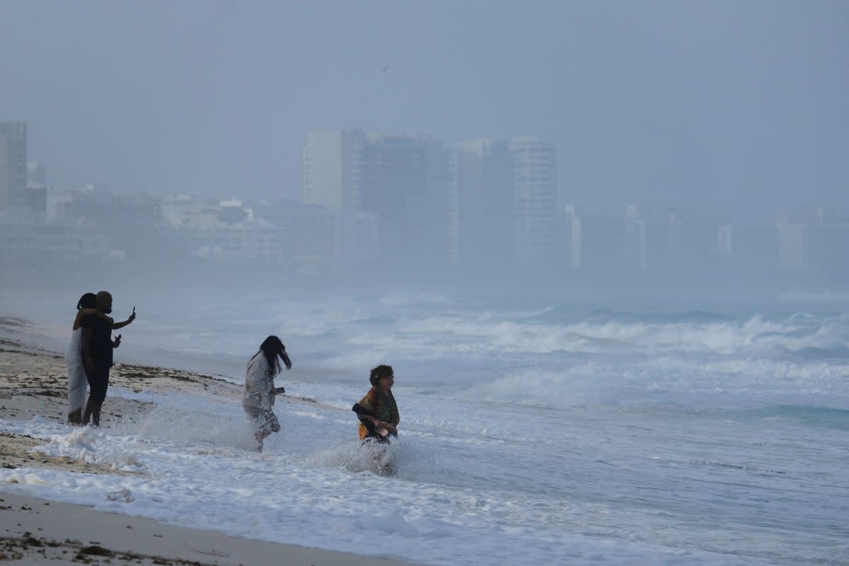 People enjoy the beach ahead of the arrival of Hurricane Beryl, in Cancun (REUTERS)