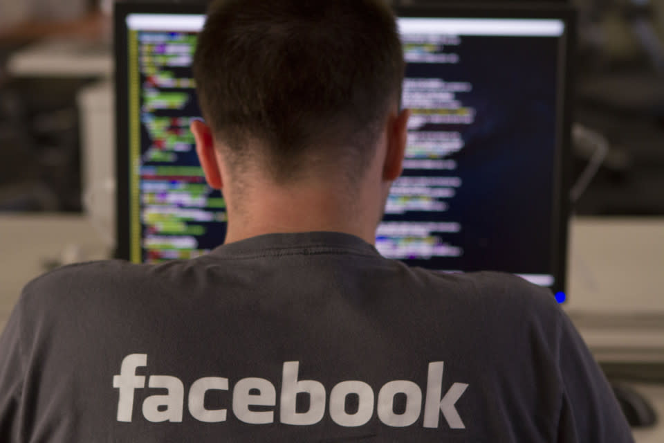 A Facebook engineer writing computer code on his laptop.