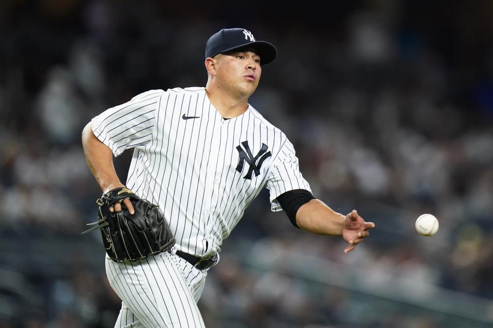 New York Yankees relief pitcher Manny Banuelos tosses the ball for the out on Detroit Tigers' Willi Castro at first base during the ninth inning of a baseball game Friday, June 3, 2022, in New York. The Yankees won 13-0. (AP Photo/Frank Franklin II)