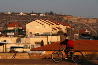 A boy rides his bicycle past houses in the Israeli settlements of Ofra, in the occupied West Bank February 6, 2017. REUTERS/Baz Ratner