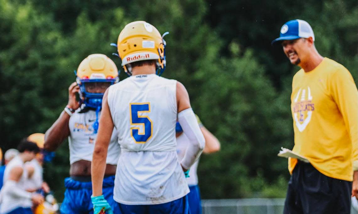 Lexington coach Perry Woolbright, right, talks to his son Brayden during a 7-on-7 this summer against Camden.