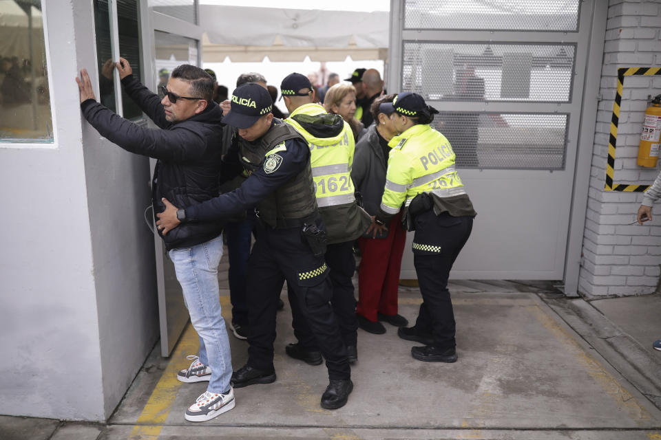 Police frisks voters during local and regional elections in Bogota, Colombia, Sunday, Oct. 29, 2023. (AP Photo/Ivan Valencia)