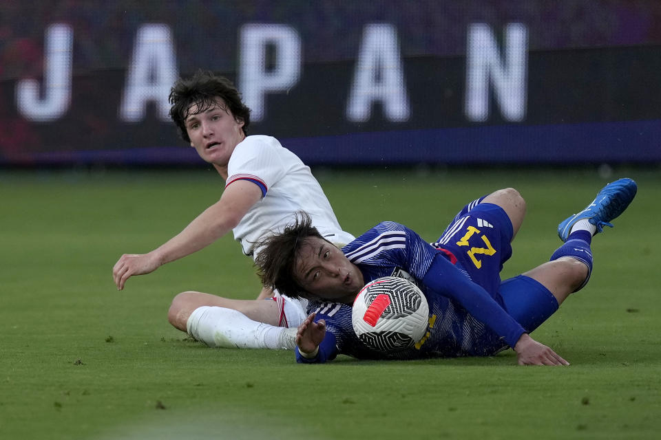 United States midfielder Paxten Aaronson and Japan defender Ayumu Ohata (21) chase the ball during the first half of an international friendly under-23 soccer match Tuesday, June 11, 2024, in Kansas City, Kan. (AP Photo/Charlie Riedel)