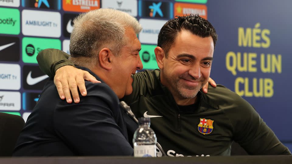 Xavi and Laporta embrace at Thursday's press conference. - Lluis Gene/AFP/Getty Images