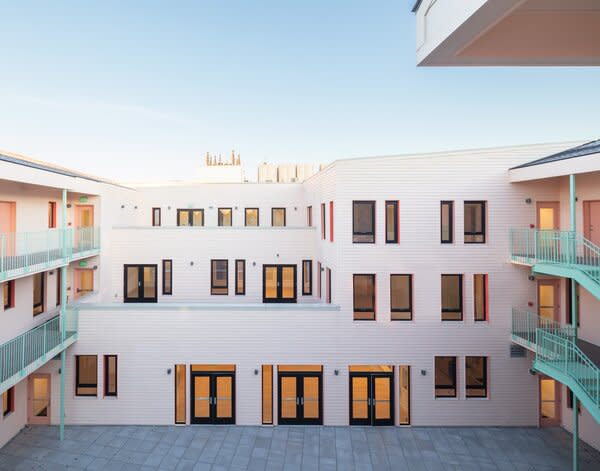 Boston architecture firm French 2D designed the Bay State Cohousing building outside Boston for 30 families to share. Three stories wrap around a central courtyard, which is enlivened by a range of pastel colors spread across railings, windows, doors, and walls.