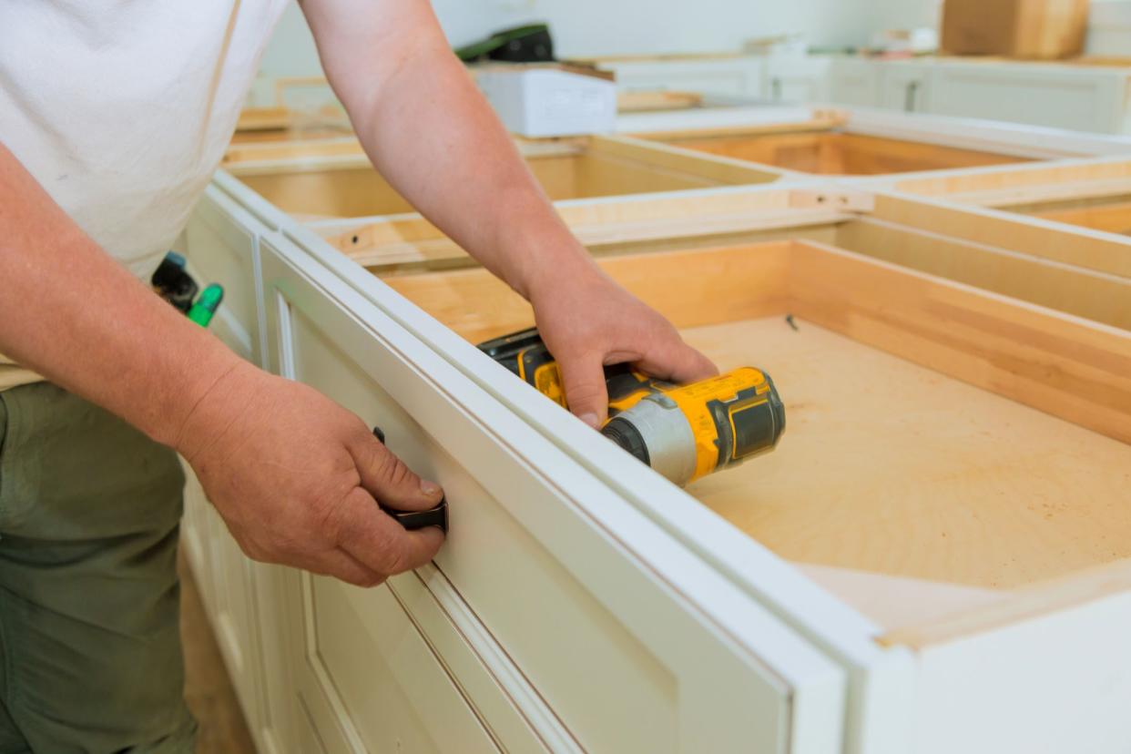 Installation of measuring drawers handles on kitchen cabinets